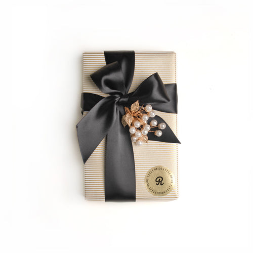 1/2 lb fancy wrapped box. Gold, and white pin-stripped wrapping paper. Tied with a black satin ribbon and white decorative piece